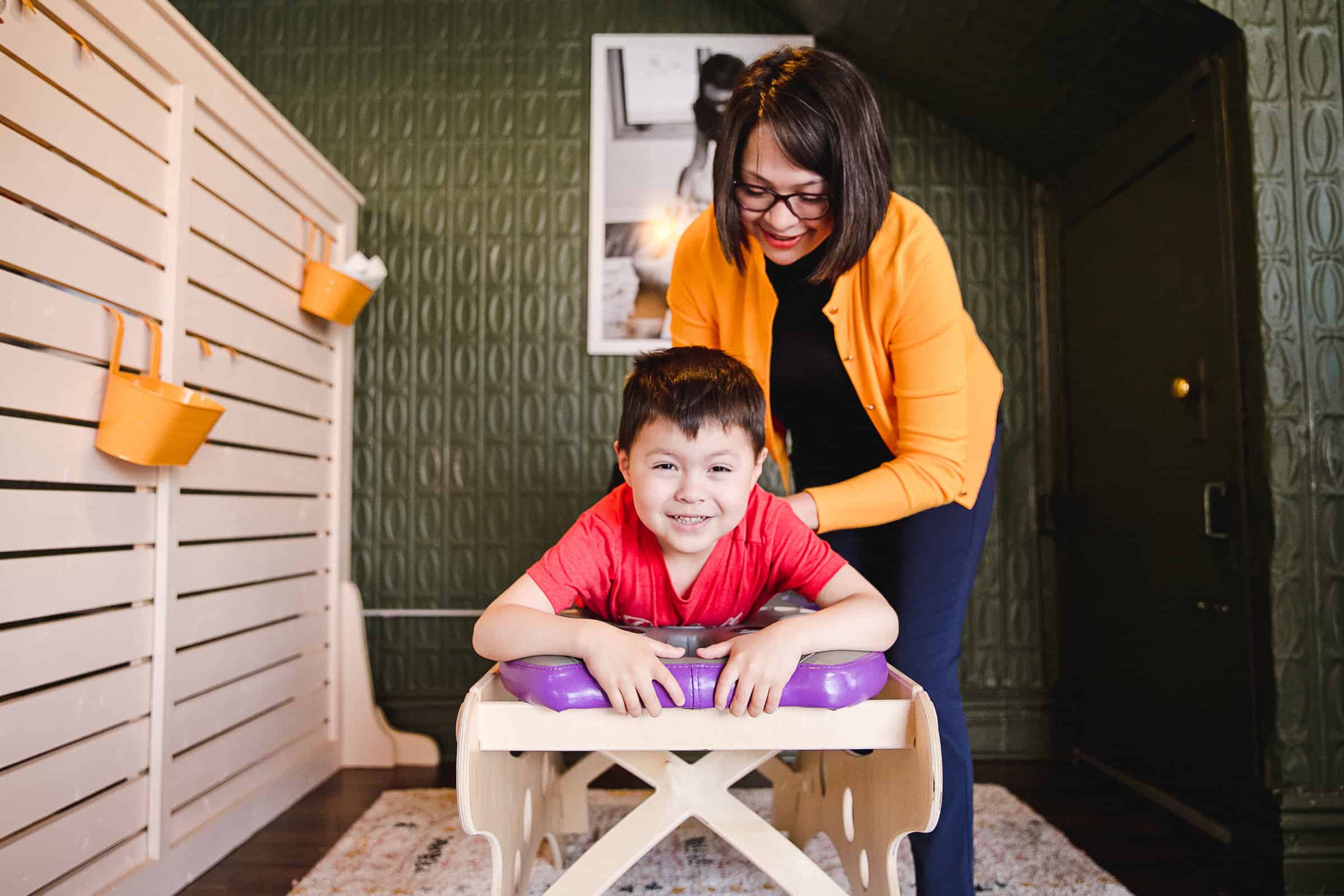 Child receiving chiropractic care from a smiling female chiropractor in a modern clinic.