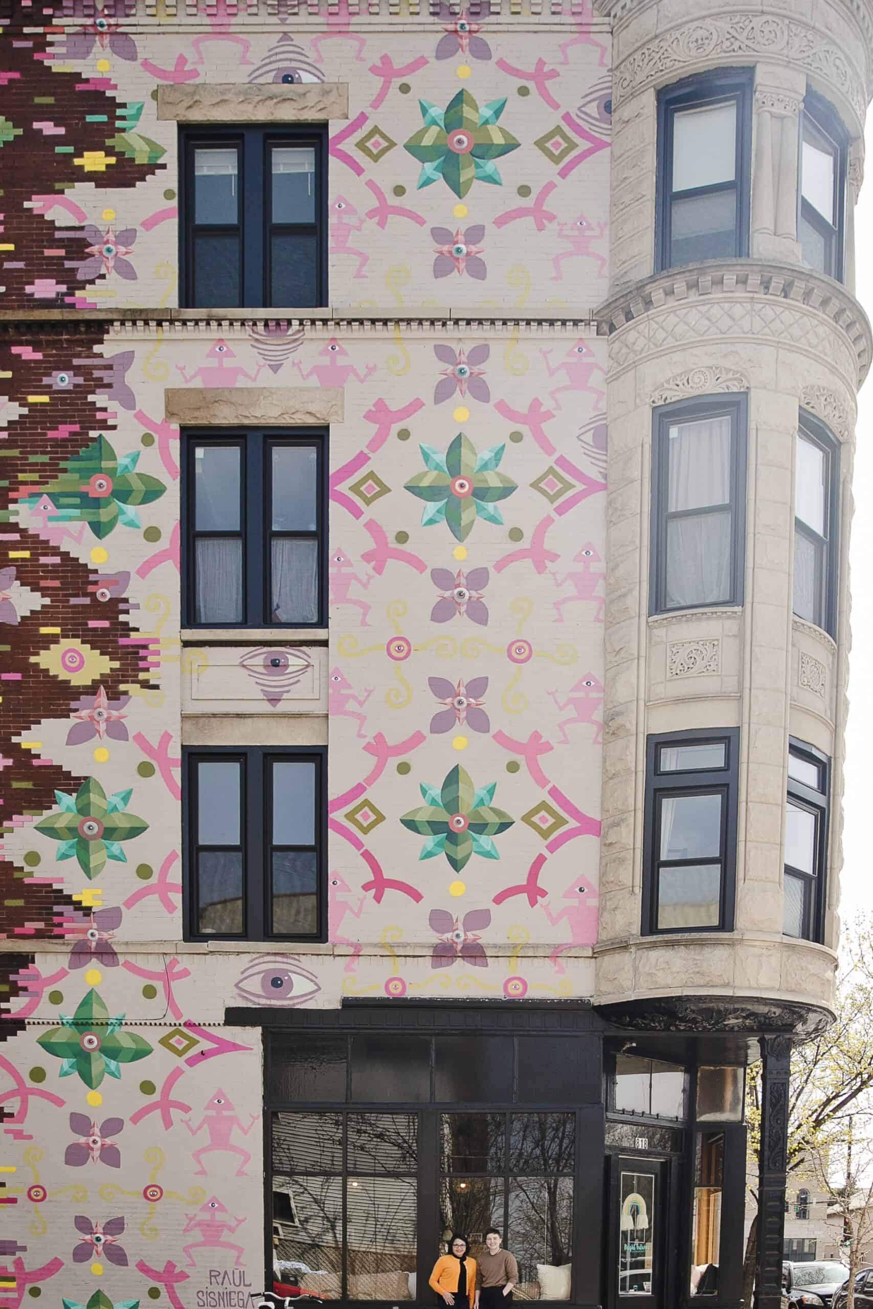 Colorful mural on building exterior with floral and geometric patterns.