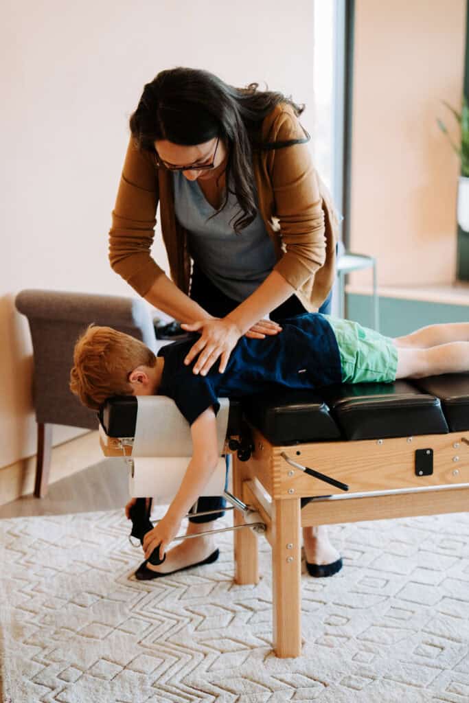 Child receiving chiropractic adjustment from a chiropractor in a clinic setting.